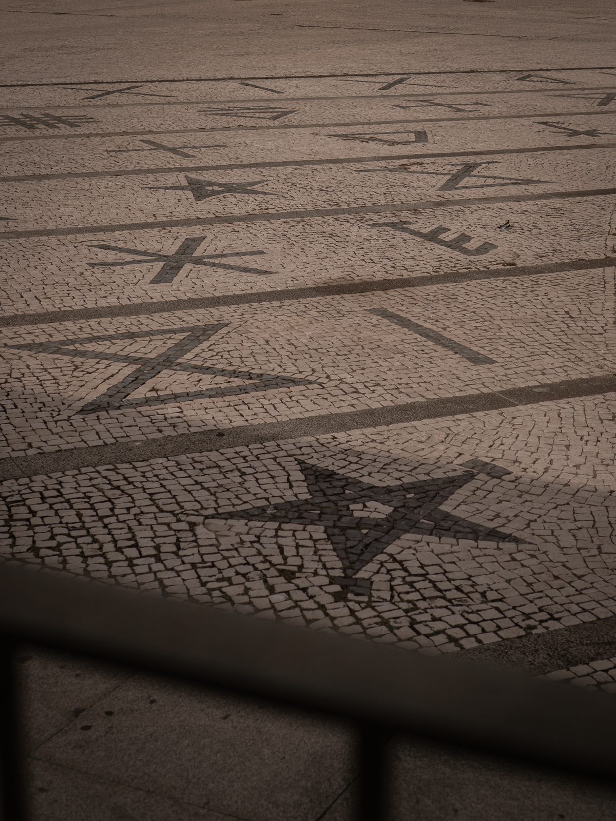 Siglas poveiras desenhadas em calçada portuguesa no Passeio Alegre