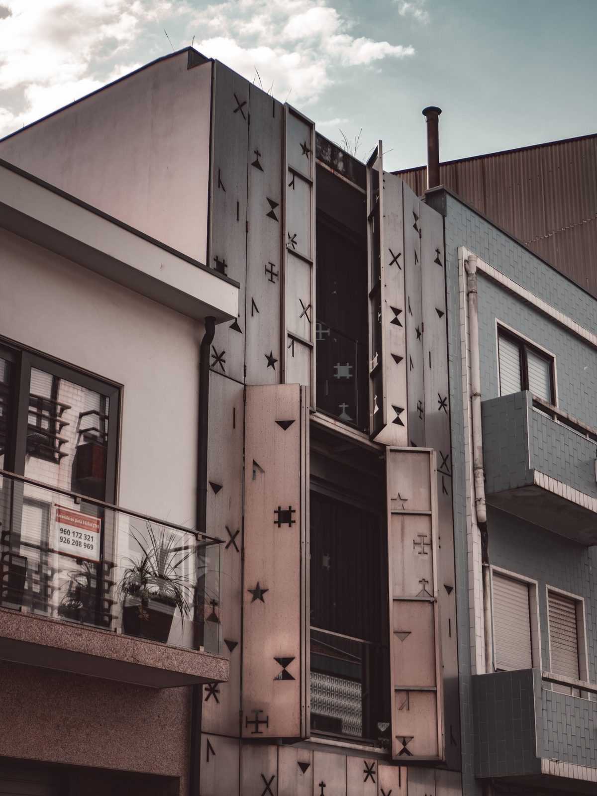 Vista de rua de habitação com portadas recortadas com siglas poveiras
