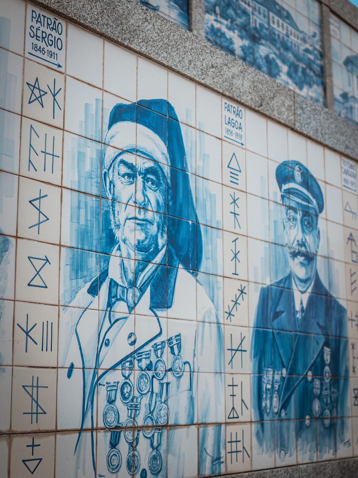 Painel de azulejos com retratos do Patrão Sérgio e do Patrão Lagoa, acompanhados pelas suas siglas